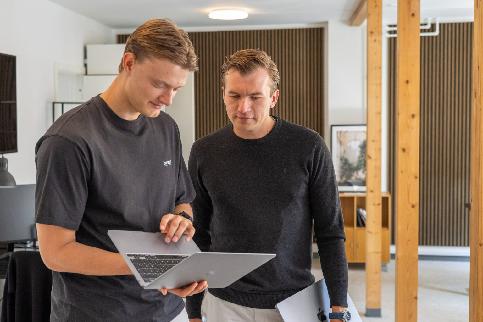 To kollegaer diskuterer et projekt på kontoret