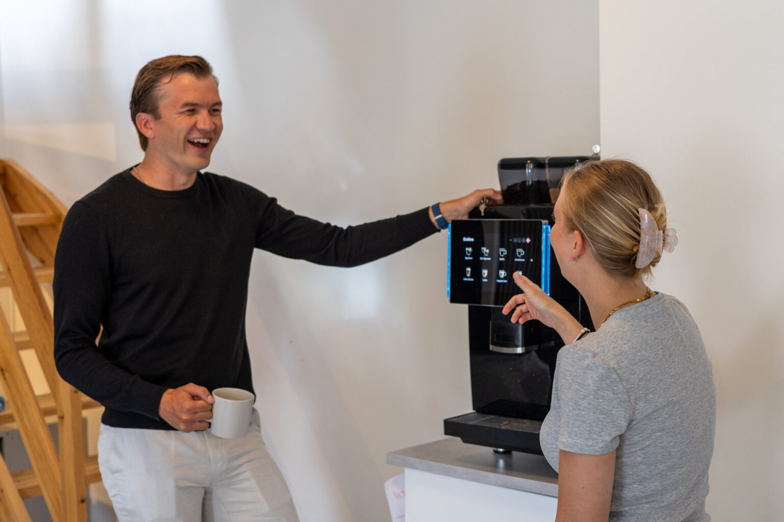 Kollegaer griner ved kaffemaskinen